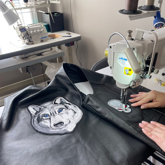 Leather jacket being sewn under sewing machine